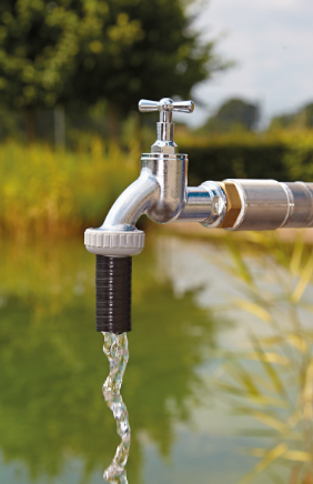 Wasserhahn bei der Befüllung eines Gartenteichs mit frischem Leitungswasser