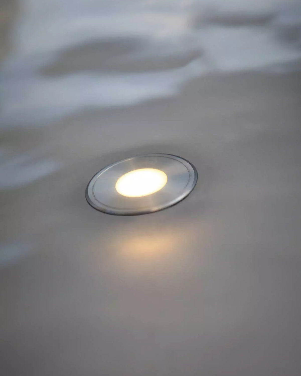 Leuchtende LunAqua Terra LED in einer nassen Fläche am Wasser