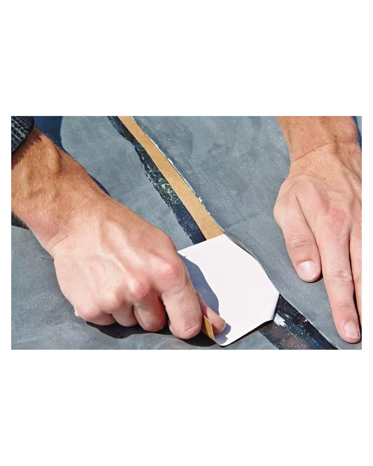 Das Schutzpapier des SeamTape wird zwischen den Folienbahnen herausgezogen