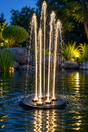 OASE Water Starlet Wasserspiel mit fünf beleuchteten Fontänen im Gartenteich bei Dämmerung