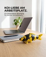 Ki Utsuri Fischfigur als besondere Deko auf dem Schreibtisch neben Laptop und Pflanze