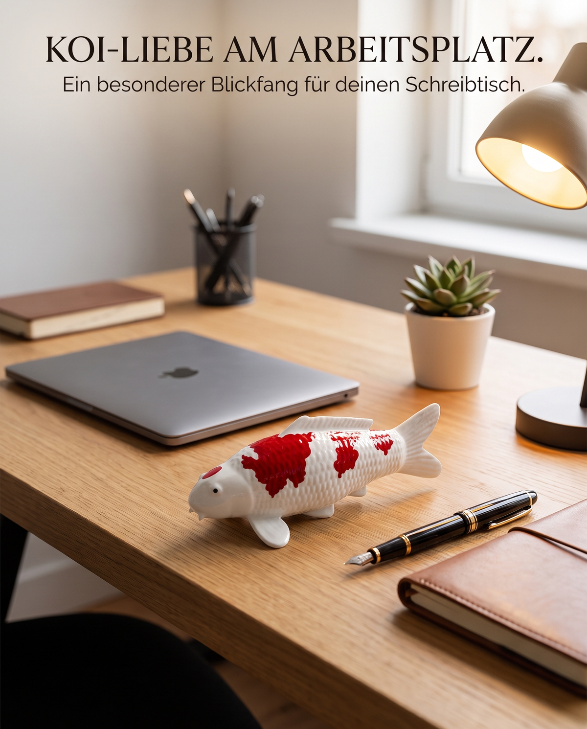 Handbemalte Koi Figur rot weiss auf Holzschreibtisch mit Laptop Füller Notizbuch Tischlampe Pflanze als dekorativer Blickfang im Arbeitsbereich