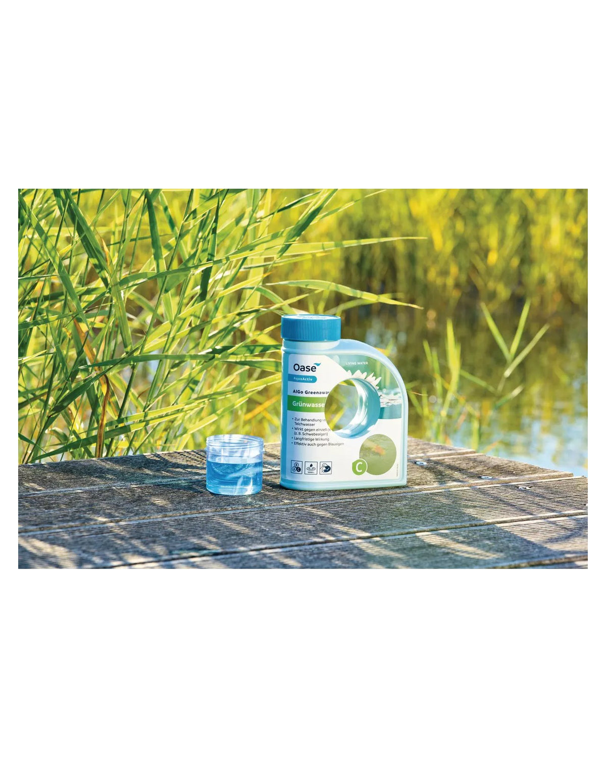 AlGo Greenaway 500 ml mit Messbecher auf einem Holzsteg am Teich
