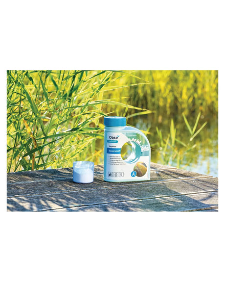 OASE OxyPlus Flasche und Messbecher mit weißem Granulat auf einem Holzsteg am Teich