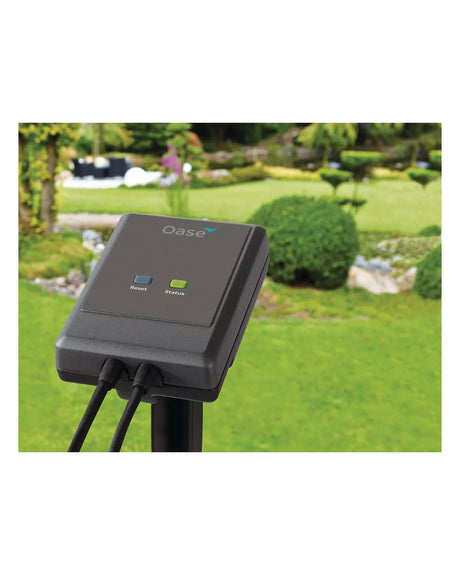 OASE Garden Controller Cloud auf dem Erdspieß im Garten vor Rasen und Buchskugeln