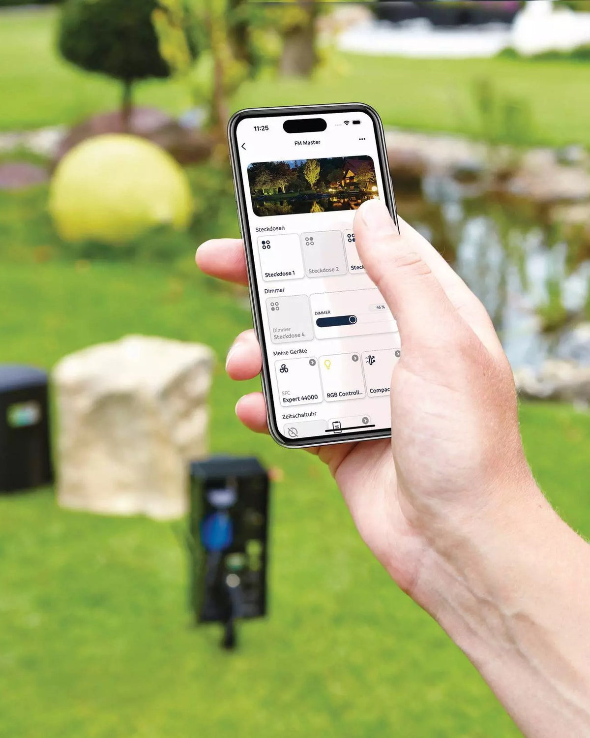 OASE Control App mit Steckdosen, Dimmer und Geräten, dahinter der InScenio FM-Master Cloud im Garten