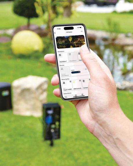 OASE Control App mit Steckdosen, Dimmer und Geräten, dahinter der InScenio FM-Master Cloud im Garten