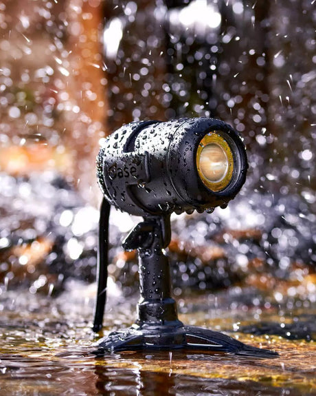 LunAqua-Connect-Spot auf dem Standfuß im flachen Wasser, umgeben von Spritzwasser