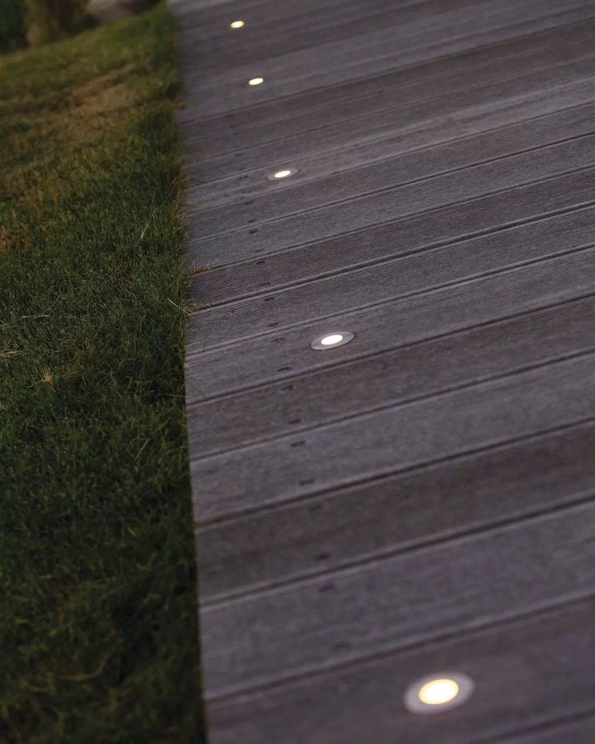 Holzsteg mit einer Reihe LunAqua Terra LED in der Dämmerung