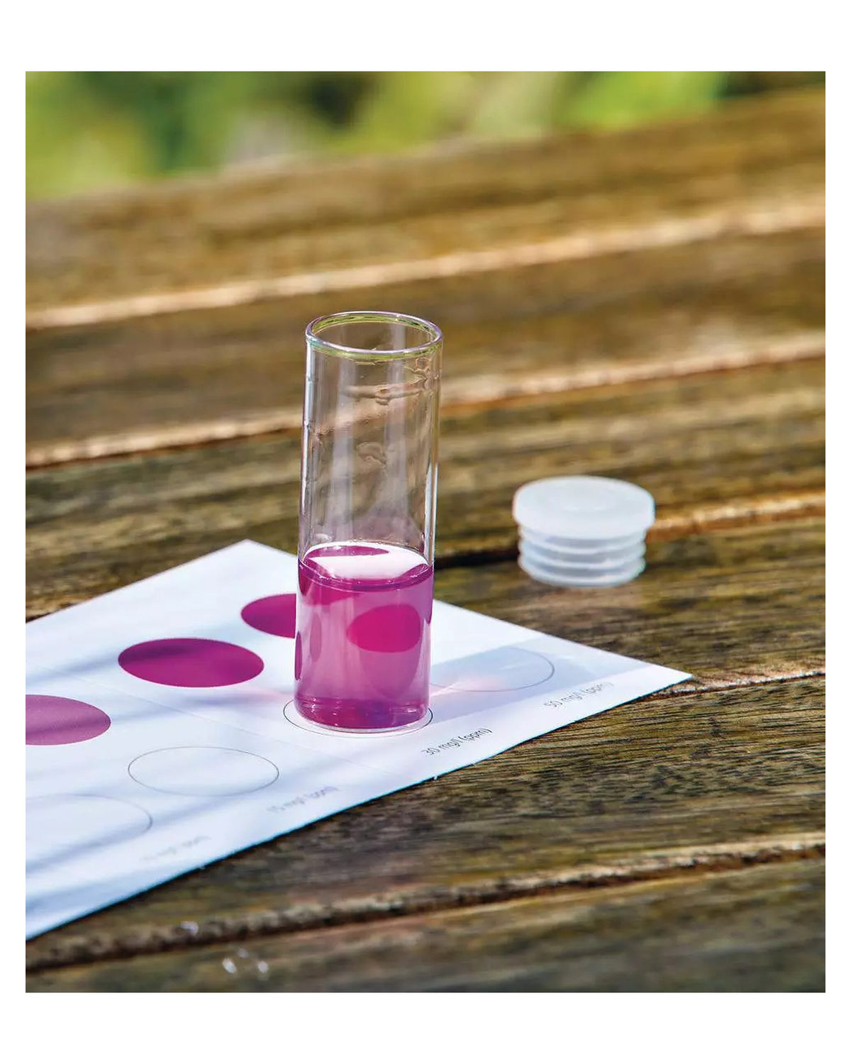 Nitrit-/Nitrat-Test mit dem OASE Profi-Set: Glasampulle mit pinker Probe auf der Farbkarte