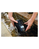 Ein Water Jet des OASE Water Jet Lightning wird in einen flachen Wasserlauf gestellt
