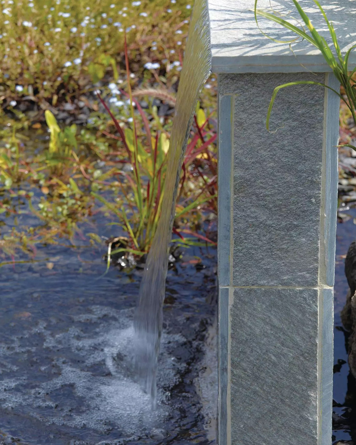OASE Waterfall in einer Natursteinsäule, das Wasser fällt in den Teich